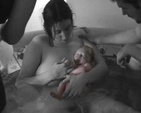 Mother and newborn with umbilical cord still a...