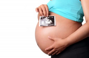 Pregnant woman holding ultrasound print