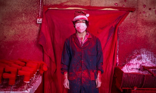 Photo by Imaginechina/REX (4301626b) 19-year-old worker Wei wearing a face mask and a Christmas hat covered in red powder Christmas decorations being made at a factory in Yiwu city, Zhejiang province, China - 15 Dec 2014